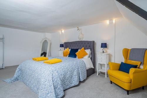 Un dormitorio con una cama y una silla amarilla. en 5 Central Chambers, en Stratford-upon-Avon