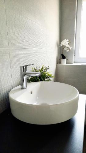 a white sink with a faucet in a bathroom at Molo Wellness Garden in Siófok