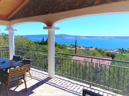 porche con mesa y vistas al océano en STONE VILLA-MILAN Pool Sea View Lounge Room en Starigrad-Paklenica