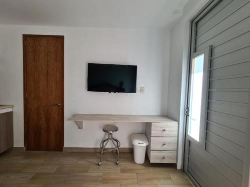 um quarto com um WC e uma televisão na parede em Acogedor loft privado em Cidade do México