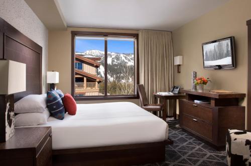 テトン・ビレッジにあるHotel Terra Jackson Hole, a Noble House Resortのベッドと大きな窓が備わるホテルルームです。