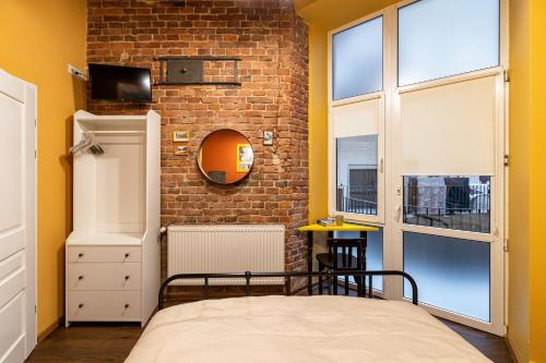 a bedroom with a bed and a brick wall at Post House Rooms in Lviv