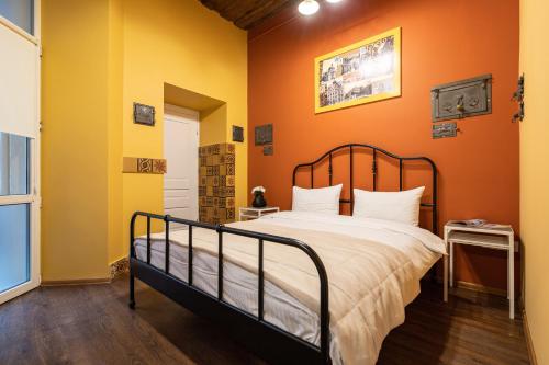 a bedroom with a bed with orange walls at Post House Rooms in Lviv