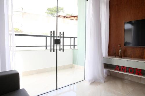 sala de estar con puerta corredera de cristal y TV en Apartamento Premium en Diamantina