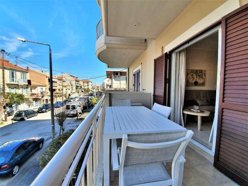 einen Balkon mit einem Tisch und Straßenblick in der Unterkunft Kainon Asti in Lefkada Town