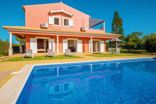 une villa avec une piscine en face d'une maison dans l'établissement Villa Sunrise by Algarve Vacation, à Carvoeiro