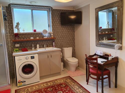 ein Badezimmer mit einer Waschmaschine und einem Waschbecken in der Unterkunft Bed and Breakfast in Cooranbong