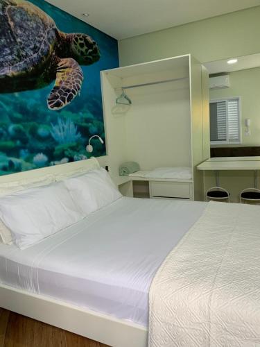 a bedroom with a bed with a turtle mural on the wall at Suite Turtle in Guarujá
