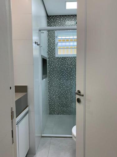 a bathroom with a shower with a glass door at Suite Turtle in Guarujá