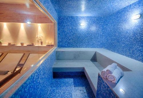 ブラジリアにあるApart Hotel Fusion Estacionamento Grátis A007の青いタイル張りのバスタブ付きの青いバスルーム
