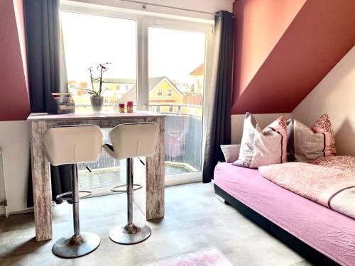 ein Schlafzimmer mit einem Tisch, einem Bett und einem Fenster in der Unterkunft Eigenes Apartment im Herzen der Stadt mit Balkon und WLAN II in Cottbus