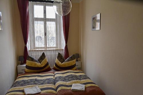 a bed with pillows on it with a window at Apartmán Náměstí Hostinné in Hostinné