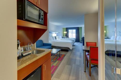 a hotel room with a kitchen and a living room at Holiday Inn Express Hotel & Suites Dayton-Centerville by IHG in Centerville