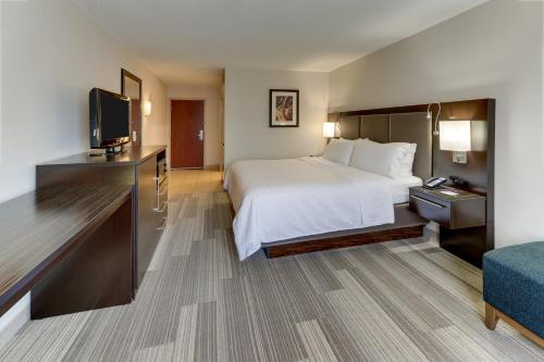 a hotel room with a bed and a flat screen tv at Holiday Inn Express Hotel & Suites Dayton-Centerville by IHG in Centerville
