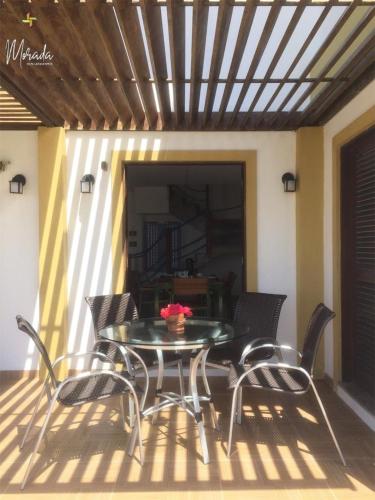a patio with a table and chairs on a deck at Morada dos Cataventos (Frente Mar) in Barra de Camaratuba
