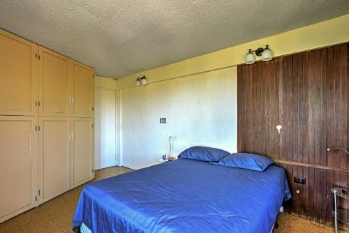 a bedroom with a blue bed and wooden cabinets at Tropical Ponce Home Private Pool and Outdoor Oasis! in Ponce
