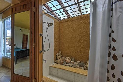 a bathroom with a shower with a stone wall at Tropical Ponce Home Private Pool and Outdoor Oasis! in Ponce