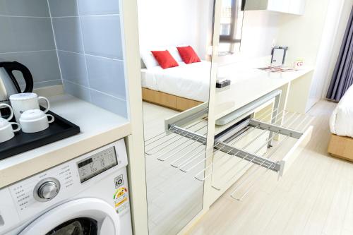 a washing machine in a bathroom next to a room at Shin Shin Hotel Seogwipo in Seogwipo