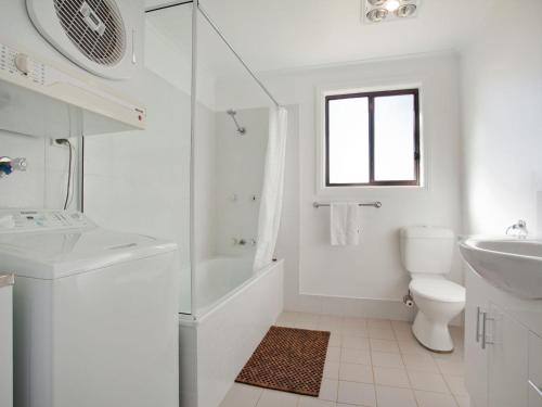 La salle de bains blanche est pourvue de toilettes et d'un lavabo. dans l'établissement Kestrels Rest 2 116 Gippsland Street, à Jindabyne