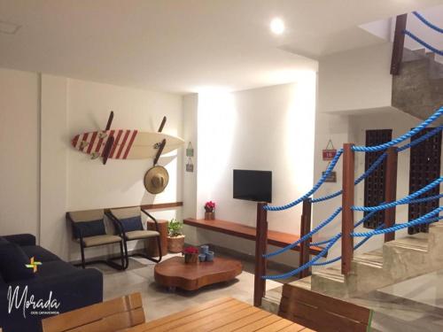 uma sala de estar com uma escada com uma prancha de surf na parede em Morada dos Cataventos (Frente Mar) em Barra de Camaratuba