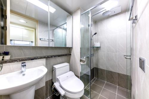 a bathroom with a toilet and a sink and a shower at Shin Shin Hotel Seogwipo in Seogwipo