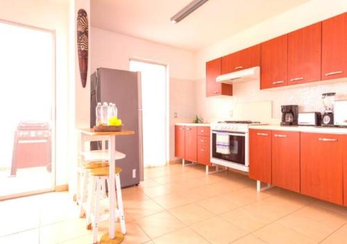 a kitchen with red cabinets and a stainless steel refrigerator at Family Home close to the Beach, Vidanta, Aqua Adventures with Pool & Parking in Nuevo Vallarta