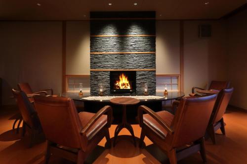 a dining room with a fireplace and a table and chairs at Hanashibuki in Tateyama