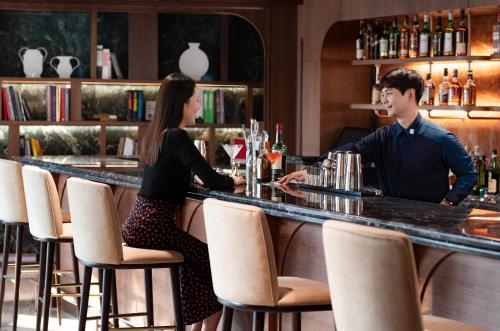 a man and a woman sitting at a bar at Mondrian Seoul Itaewon in Seoul