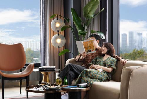 a man and woman sitting on a couch in a living room at Mondrian Seoul Itaewon in Seoul