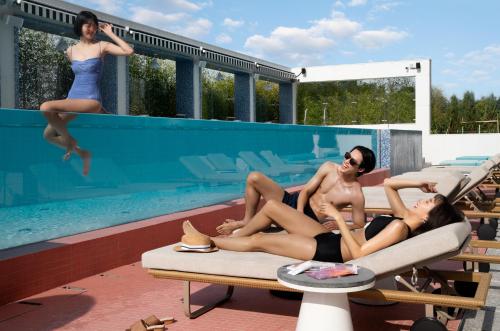 a group of three people laying on a swimming pool at Mondrian Seoul Itaewon in Seoul
