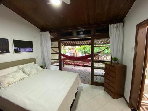 サルバドールにあるCasa Tropical pé na areiaのベッドとガラスの引き戸のある寝室