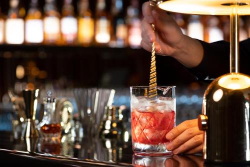 a person is stirring a drink with a straw at Mondrian Seoul Itaewon in Seoul