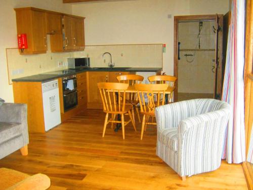 a kitchen with a table and chairs in a room at The Stables in Bromyard