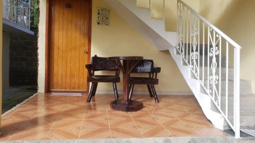 a wooden table and two chairs next to a staircase at Posada Dos Hermanos in Huasca de Ocampo