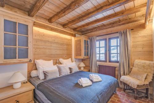 une chambre avec un lit et une chaise dans une pièce dans l'établissement Chalet Les Meuniers, à Megève