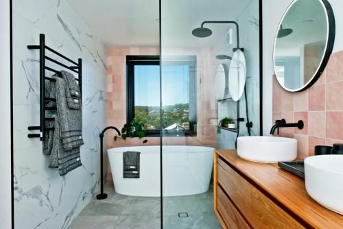a bathroom with a tub and two sinks and a mirror at 52Views Castlemaine in Castlemaine