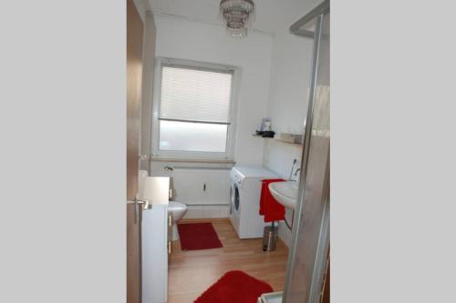 uma casa de banho com um lavatório, um WC e uma janela. em Apartment in the heart of Nuremberg em Nurembergue
