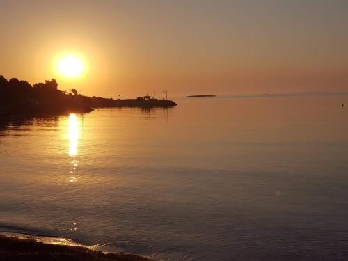 a sunset over a body of water at Eleni B&B in Limánion