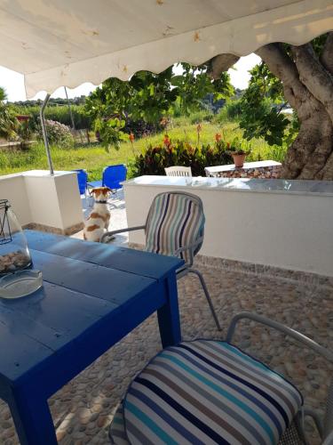 een blauwe tafel en een stoel onder een paraplu bij Eleni B&B in Limánion