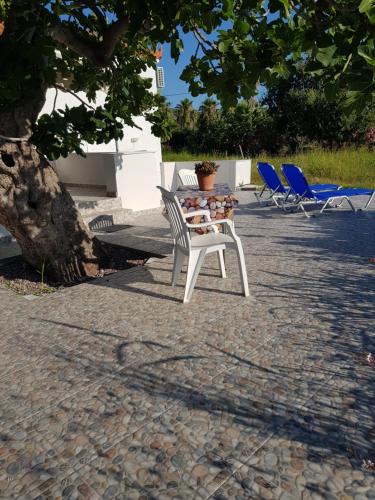 a white chair sitting next to a table and chairs at Eleni B&B in Limánion