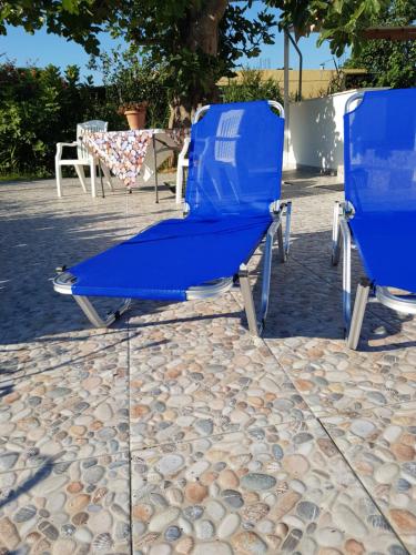 two blue beach chairs sitting on a pebblelled patio at Eleni B&B in Limánion