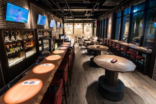 a bar with wooden tables and chairs in a restaurant at La'gent Hotel Shinjuku Kabukicho in Tokyo
