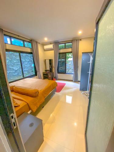a bedroom with a bed in a room with windows at AL Marina Resort in Puncak