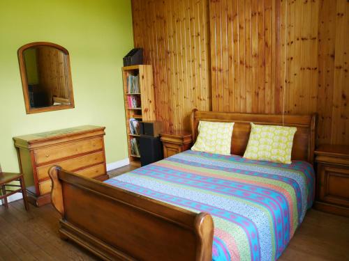 1 dormitorio con cama, tocador y espejo en Le nichoir d’hirondelles en Tintigny