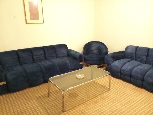 a living room with two couches and a coffee table at Oriental Palace Hotel in Manama