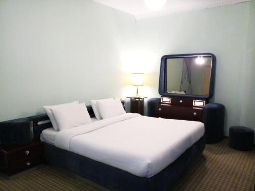 a hotel room with a large bed and a tv at Oriental Palace Hotel in Manama
