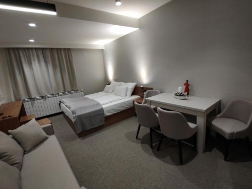 Habitación de hotel con cama, mesa y sillas en Star Hill - Koznik Konaci en Kopaonik
