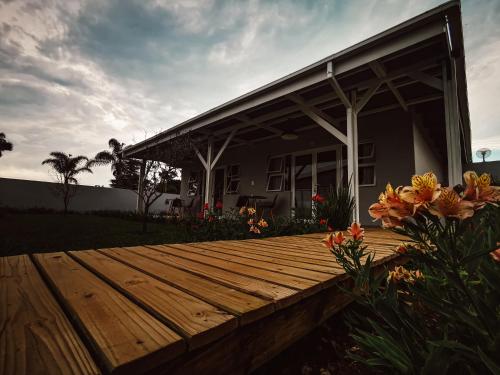 a wooden deck in front of a house with flowers at Mosswood Bed & Breakfast in Graskop