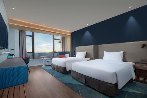 晋江市にあるHoliday Inn Express Jinjiang Anhai, an IHG Hotelのベッド2台と窓が備わるホテルルームです。