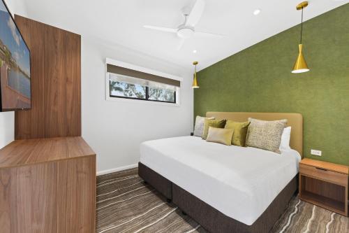 a bedroom with a bed and a green wall at Club Wyndham Flynns Beach, Trademark Collection by Wyndham in Port Macquarie